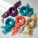 Premium lightweight scarves and stoles flat lay in vibrant colours on white marble surface